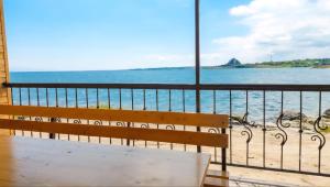 a bench sitting on a balcony looking out at the ocean at Tsovazard Holiday House in Tsovazard