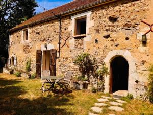 a stone building with a table and chairs in front of it at La Masure in Les Rameaux