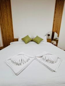 a white bed with a bow tie on it at Meena boutique in Ban Nai Wat