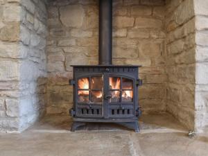 an open stove in a stone wall at Wren Cottage in Lydney
