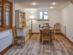 a kitchen and dining room with a table and chairs at Wren Cottage in Lydney
