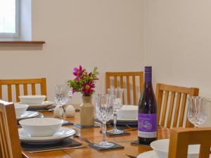 a table with a bottle of wine and glasses at Wren Cottage in Lydney