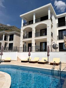 a hotel with a swimming pool in front of a building at Sea View Residence with Pool & Private Terrace in Krstac