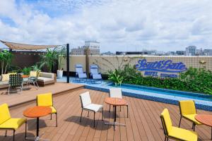 a rooftop patio with chairs and tables and a pool at South Gate Hotel Okinawa Naha Tomari Port - Direct Access to Tomarin in Naha