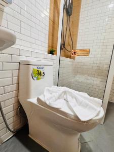 a toilet in a bathroom with a price sign on it at Meena boutique in Ban Nai Wat