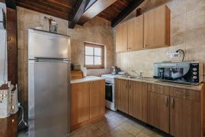 a kitchen with wooden cabinets and a stainless steel refrigerator at Villa Robinson in Petrovac na Moru +42 photos