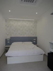 a bedroom with a large bed with a blue headboard at Mgd House in Santa Domenica