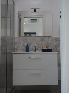 a bathroom with a white sink and a mirror at Mgd House in Santa Domenica +11 photos