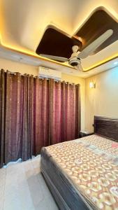 a bedroom with a bed with curtains and a ceiling at Complete Comfy House with 3 beds Al-Hafeez Garden Lahore in Lahore