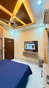 a bedroom with a bed and a flat screen tv at Complete Comfy House with 3 beds Al-Hafeez Garden Lahore in Lahore