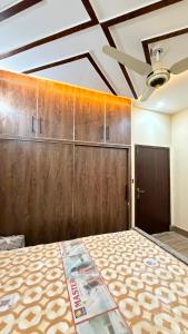 a room with a bed with wooden panels and a door at Complete Comfy House with 3 beds Al-Hafeez Garden Lahore in Lahore +4 photos