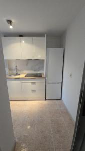 a kitchen with white cabinets and a refrigerator at WHITE TREE Azalea in Ferrol