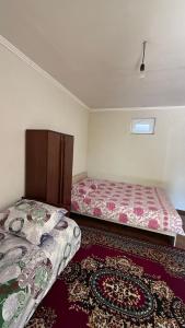 a bedroom with two beds and a rug at Aiperii in Bosteri +5 photos