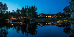 a view of a lake at night with houses at Toten Hotel Sillongen in Eklund