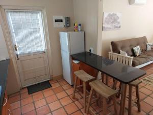 a kitchen with a refrigerator and a table and chairs at Springbok Cottage in Graaff-Reinet