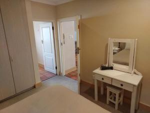 a room with a dressing table and a mirror at Springbok Cottage in Graaff-Reinet +7 photos