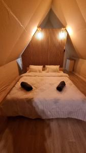 a bedroom with a large bed with two pillows on it at Veselia Glamping in Valea Drăganului