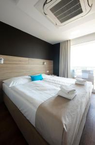 a bedroom with a large white bed with blue pillows at Residence Šírava *** in Kaluža +80 photos