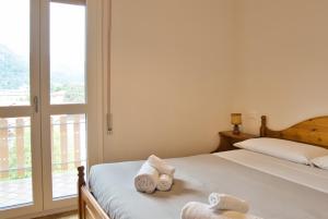 a bedroom with a bed and a window with towels at Casa Rachele - mountain panorama in Cassina Valsassina