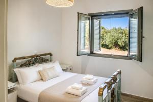 a bedroom with a bed with two towels on it at Olive Coast Houses in Kyparissia