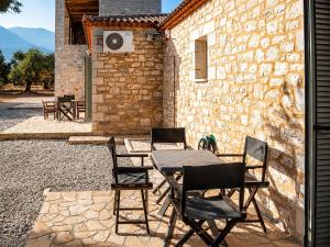 a patio with a table and chairs in front of a building at Olive Coast Houses in Kyparissia