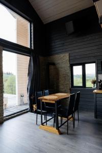 a dining room with a wooden table and chairs at Horizon Славсько з чаном,басейном in Khashchovanoye