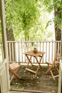 a wooden table and two chairs on a porch at Pērlerada room in Engure