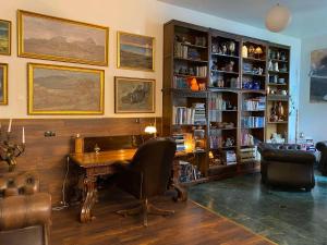 a living room with a desk and bookshelves at City Hall Apartments in Borgarnes