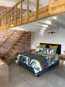 a bed in a room with a brick wall at Modern apartments downtown in Plettenberg Bay