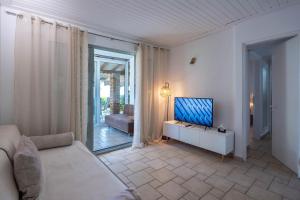 a living room with a couch and a television at Corfu Dream Holidays Villas in Glyfada +74 photos