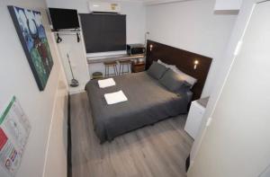 a small bedroom with a bed and a desk at Darwin city Studio in Darwin