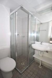 a bathroom with a shower and a toilet and a sink at Darwin city Studio in Darwin +2 photos