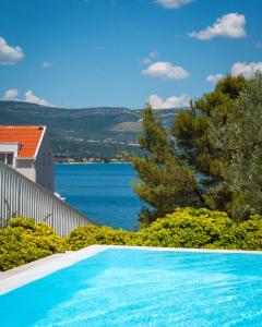 a swimming pool with a view of the water at Malo More Resort in Trogir