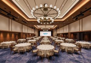 a conference room with tables and chairs and a projection screen at South Gate Hotel Okinawa Naha Tomari Port - Direct Access to Tomarin in Naha +148 photos