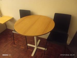 a wooden table with two black chairs around it at Telhado solitario in Porto