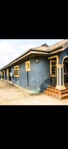 a blue house with a porch and a balcony at Mo Exortic Royale Services in Ikorodu