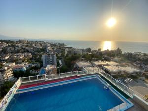 a swimming pool on top of a building with the ocean at Silver Tower Family Apart Otel in Kuşadası
