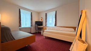 a hotel room with a bed and a desk with a computer at Hotel Heilquelle-Leukerbad-Therme in Leukerbad +39 photos