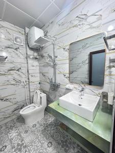 a bathroom with a sink and a toilet and a mirror at Cloudy Hotel in Ha Giang