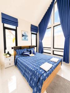 a bedroom with a blue bed with blue curtains at X2 privacy villa in Khon Kaen +15 photos