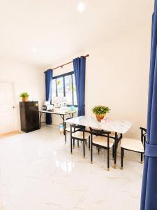 a dining room with blue curtains and a table and chairs at X2 privacy villa in Khon Kaen