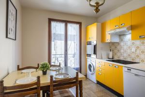 a kitchen with yellow cabinets and a table and chairs at Gîte l' Odyssée in Espalion
