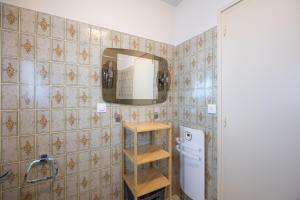 a kitchen with a white refrigerator and a mirror at Gîte l' Odyssée in Espalion