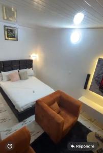 a bedroom with a bed and a chair in it at Résidence Abidjan in Abidjan