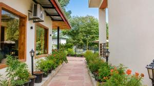 a walkway outside of a building with plants at Gauri Hayat Corbett Retreat in Rāmnagar
