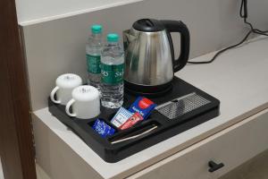 a counter with a coffee pot and water bottles at 7 Pearls in Gajendragarh