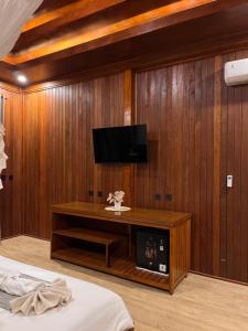 a room with a tv on a wooden wall at Villa Lumbung Sidemen in Sidemen