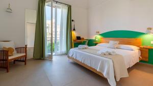 a bedroom with a large bed with a green headboard at Cava del Mare in Favignana