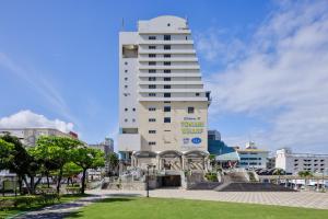 a tall white building with a sign on it at South Gate Hotel Okinawa Naha Tomari Port - Direct Access to Tomarin in Naha