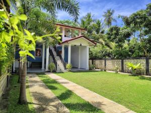 a house with a lawn in front of it at Sundaze Villa in Goyambokka